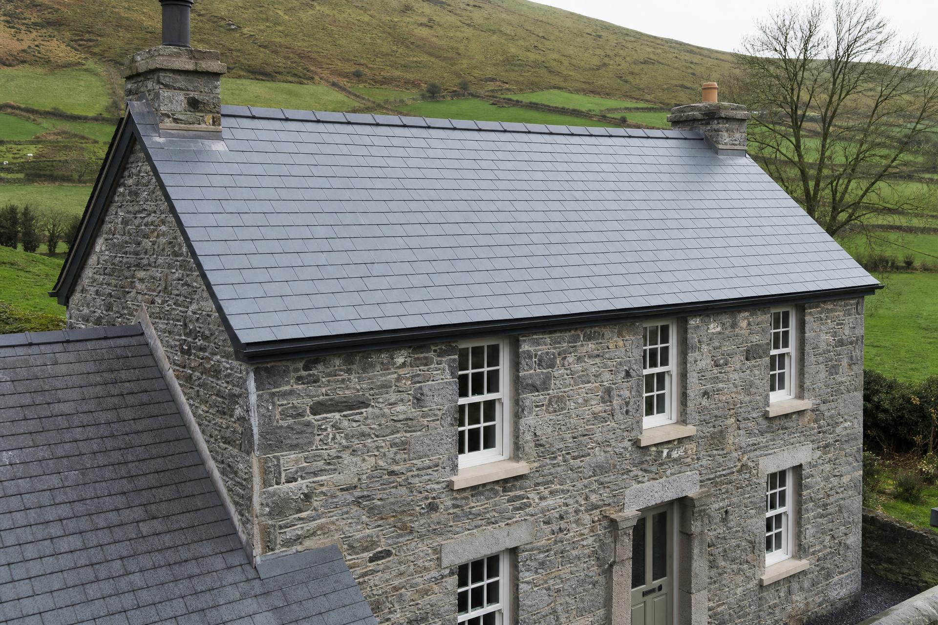 Luxury Irish stone home with a new natural slate roof at dusk